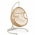 Sedia a dondolo in polyrattan con cuscino beige e struttura in metallo