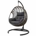 Sedia sospesa in rattan sintetico con cuscini grigio scuro e struttura in acciaio